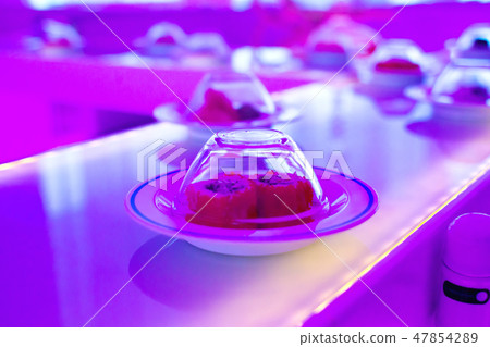 Conveyor serving sushi. Neon-purple lights 47854289
