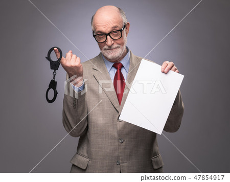 Senior man with handcuffs and paper Senior man with handcuffs and paper 47854917