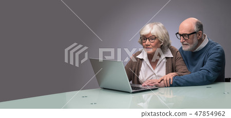 Senior couple looking at laptop Senior couple looking at laptop 47854962