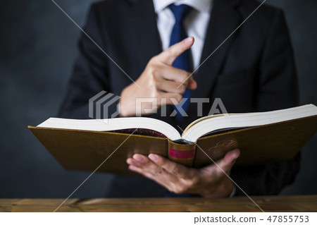 A man with a suit with a book 47855753