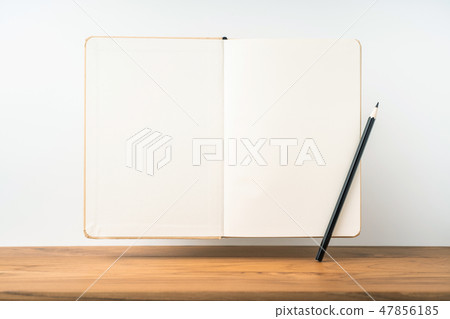 Perspective view of kraft notebook on wood floor 47856185