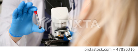 Male hand in blue protective gloves holding 47856316