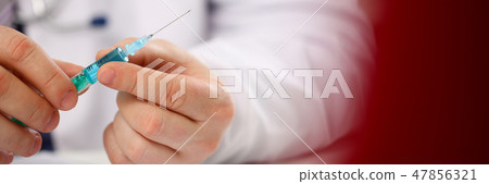 Physician injector arms in sterile uniform holding syringe Physician injector arms in sterile uniform holding syringe 47856321