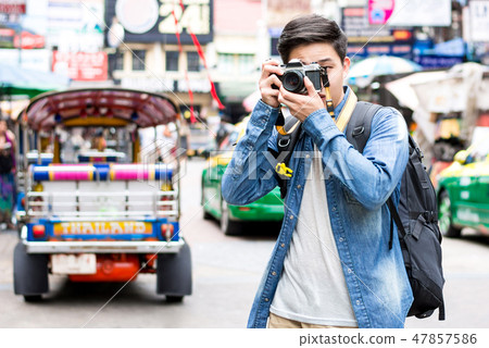 Young Asian tourist photographer taking photo  47857586