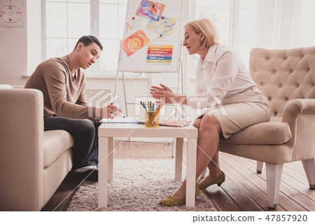 Pleased blonde woman consulting her young patient 47857920