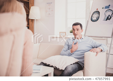 Stressed brunette man sitting opposite his doctor 47857991