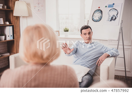 Serious male person talking to his therapist 47857992