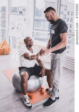 Attentive brunette young trainer consulting his client 47858066