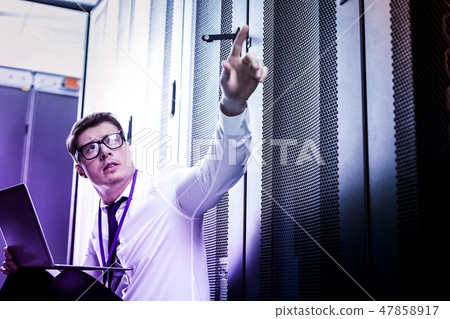 Serious nice man pointing with his finger 47858917
