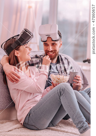 Cheerful man and woman sitting on a floor 47860657