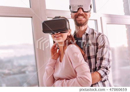 Happy man and woman standing together near the widow Happy man and woman standing together near the widow 47860659
