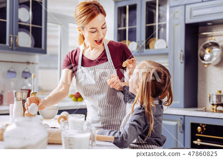Emotional woman feeling impressed while seeing cookie of her daughter Emotional woman feeling impressed while seeing cookie of her daughter 47860825