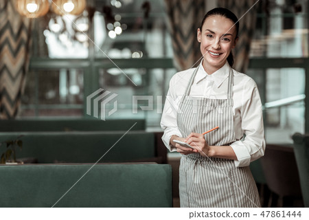 Happy young worker going to serve her visitors 47861444