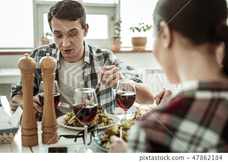 Attentive brunette man eating fresh healthy food 47862184