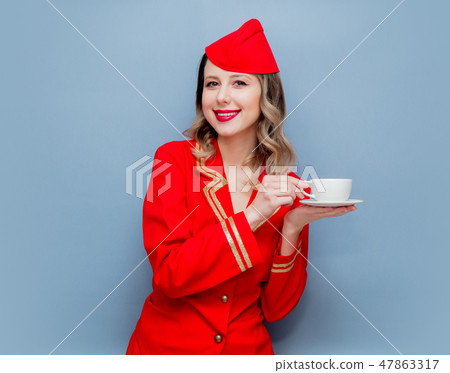 stewardess wearing in red uniform with cup of coffee or te stewardess wearing in red uniform with cup of coffee or te 47863317
