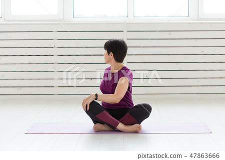 Yoga, people concept - a middle-aged woman doing a yoga and try to do a asana 47863666