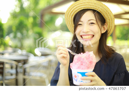 A woman eating shaved ice 47863707