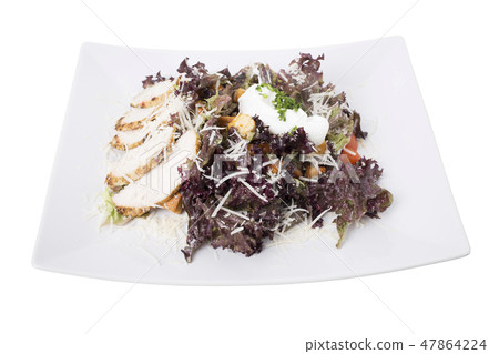 Caesar salad with chicken on a white plate. 47864224