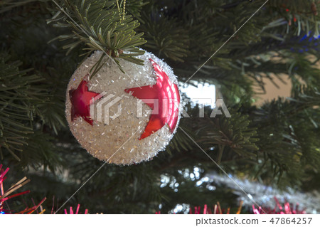 Christmas white ball on a branch of pine. 47864257