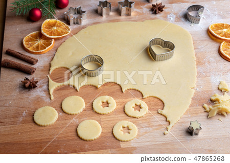 Cutting out shapes for Linzer Christmas cookies Cutting out shapes for Linzer Christmas cookies 47865268