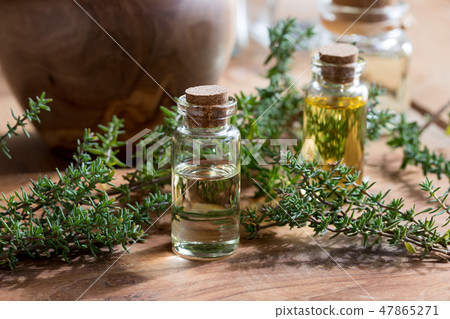 A bottle of thyme essential oil with fresh thyme A bottle of thyme essential oil with fresh thyme 47865271