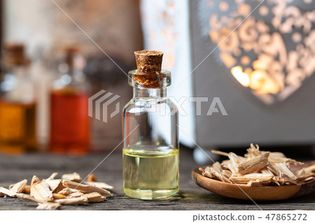 A bottle of cedar essential oil with cedar wood 47865272