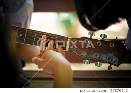 Students are learning how to play guitar Students are learning how to play guitar 47870242
