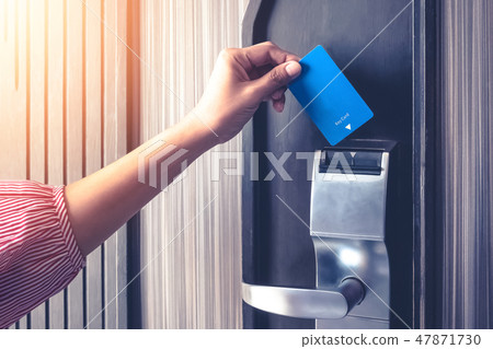 Hand inserting key card to unlock a door security authentication in the hotel or apartment safeguard Hand inserting key card to unlock a door security authentication in the hotel or apartment safeguard 47871730