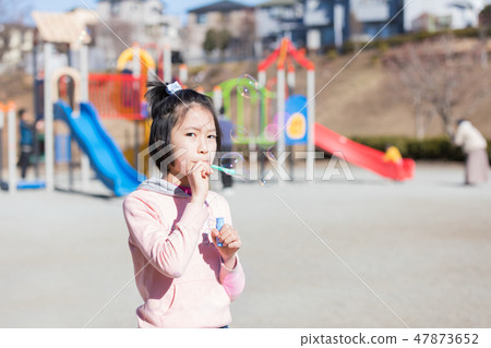 Girl playing soap bubbles Girl playing soap bubbles 47873652