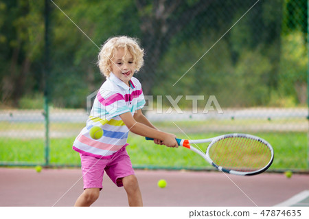Child playing tennis on outdoor court Child playing tennis on outdoor court 47874635