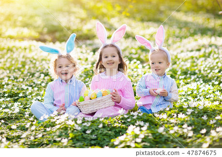 Kids with bunny ears on Easter egg hunt. Kids with bunny ears on Easter egg hunt. 47874675