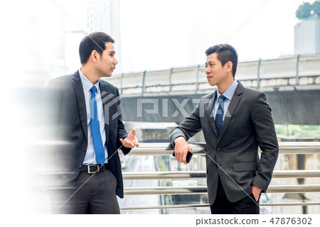 Asian businessmen talking together on a day break 47876302