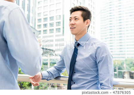 Asian Chinese businessman talking with colleague Asian Chinese businessman talking with colleague 47876305