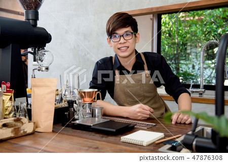 Asian entrepreneur barista sitting at counter  47876308