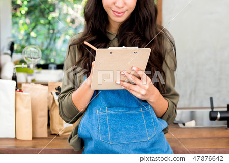 Young woman entrepreneur taking down notes at cafe Young woman entrepreneur taking down notes at cafe 47876642