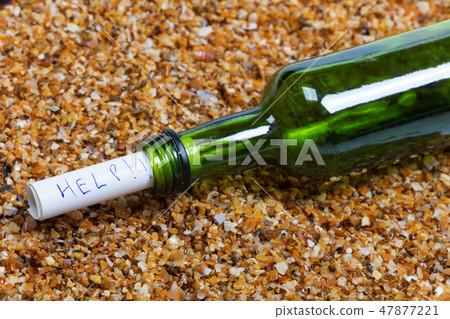 Bottle of wine with help message on wet beach 47877221