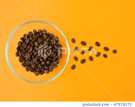Cup with coffee beans on an orange background. 47878272