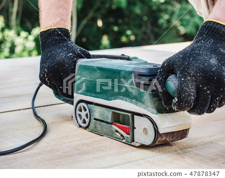 Strong men's hands and a machine for working with wood 47878347
