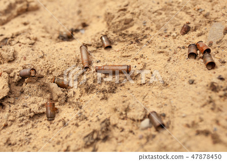 The cartridges from the cartridges lie in the sand 47878450