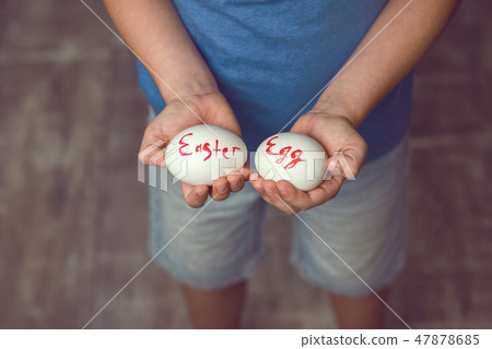 Eggs with the inscription Happy Easter the child holds in her hands in front of him. Eggs with the inscription Happy Easter the child holds in her hands in front of him. 47878685