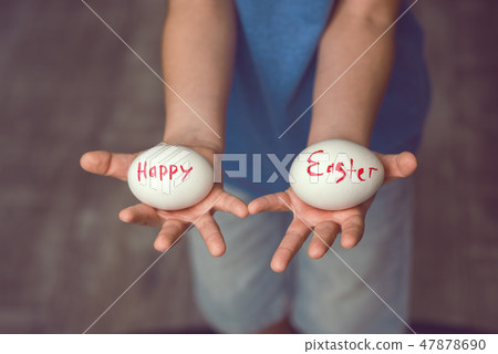 Eggs with the inscription Happy Easter the child holds in her hands in front of him. Eggs with the inscription Happy Easter the child holds in her hands in front of him. 47878690