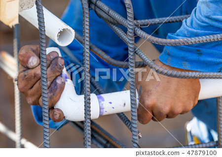 Plumber Installing PVC Pipe at Construction Site Plumber Installing PVC Pipe at Construction Site 47879100