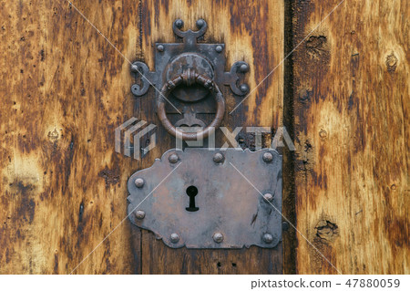 Old medieval keyhole and door knob on ancient wooden texture, closeup. 47880059