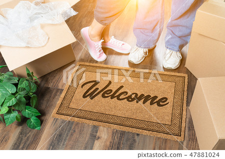 Man and Woman Stand Near Welcome Mat, Moving Boxes Man and Woman Stand Near Welcome Mat, Moving Boxes 47881024