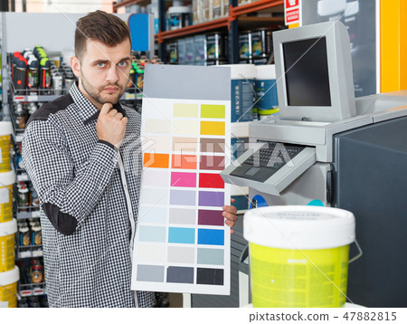 man choosing samples of color at palette 47882815