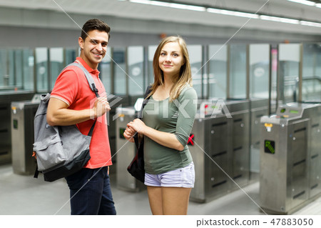 Couple is standing near turnstiles and moving around the city Couple is standing near turnstiles and moving around the city 47883050