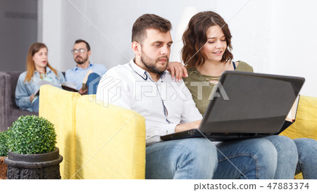 Woman and man with laptop and book 47883374