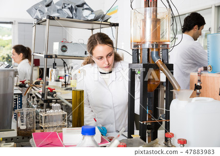 Female student working on lab equipment Female student working on lab equipment 47883983