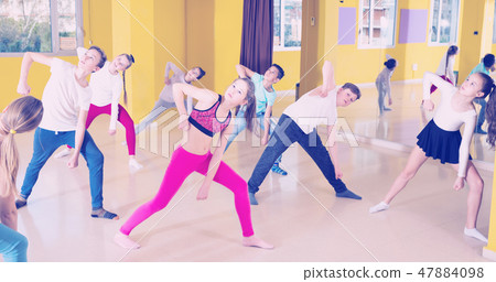 Tweens exercising with coach in choreography class 47884098