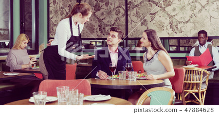 Couple talking with waitress in restaurant 47884628